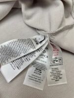 Etichette di cura per vestiti con simboli e istruzioni multilingue.