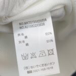 Etichetta di vestito in cotone con istruzioni di cura e codici identificativi.