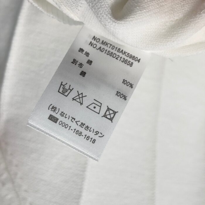 Etichetta di cura per abbigliamento giapponese con istruzioni e codici di produzione