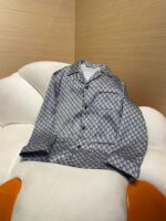 Camicia elegante blu e bianca con motivo geometrico su sedia moderna e confortevole.