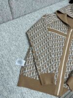 Giaccone marrone geometrico con cappuccio e tasche, stile moderno e caldo.