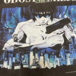 Eroina cyborg di Ghost in the Shell in città futuristica con arma, atmosfera dystopica blu e nero.