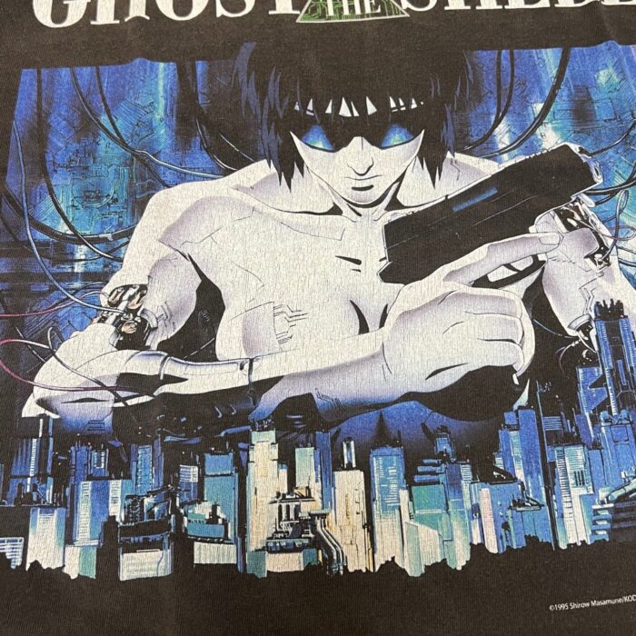 Eroina cyborg di Ghost in the Shell in città futuristica con arma, atmosfera dystopica blu e nero.