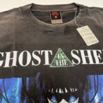 Maglietta Ghost in the Shell, stile cyberpunk, personaggio futuristico, design minimalista.