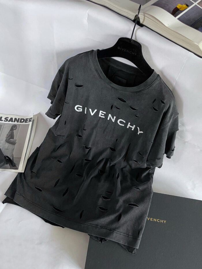 Maglietta Givenchy grigia con logo bianco e dettagli distressed, stile streetwear di lusso.