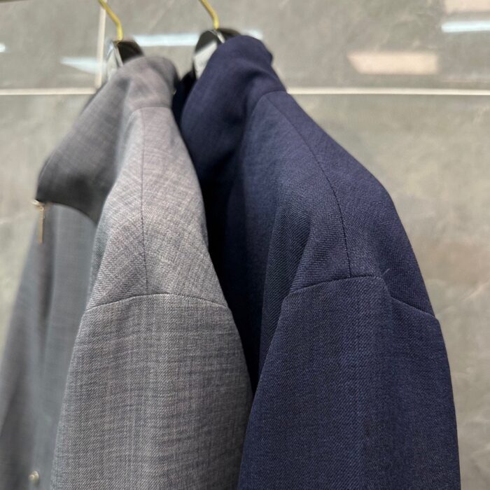 Due giacche eleganti: grigia textured e navy classica, perfette per ogni occasione.