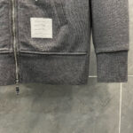 Felpa grigia con tasca zip, dettagli minimalisti, colletto a costina, stile casual moderno.