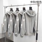 Felpe grigie moderne con grafica sul braccio, stile streetwear, esposte in negozio elegante.