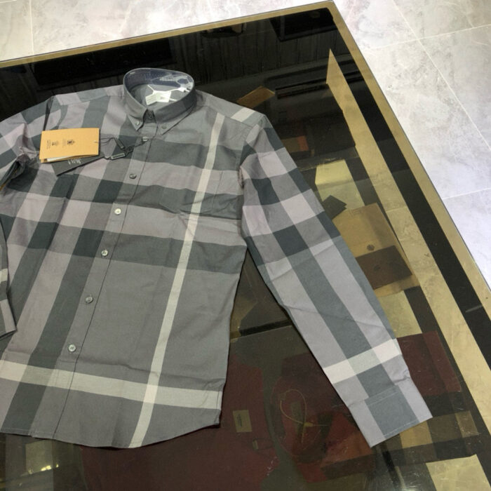 Camicia casual check grigia nuova su tavolo in vetro, stile moderno e comfort.