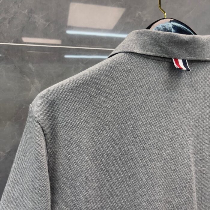 Maglietta polo grigia con dettagli colorati, stile elegante e vestibilità moderna, ideale per ogni occasione.