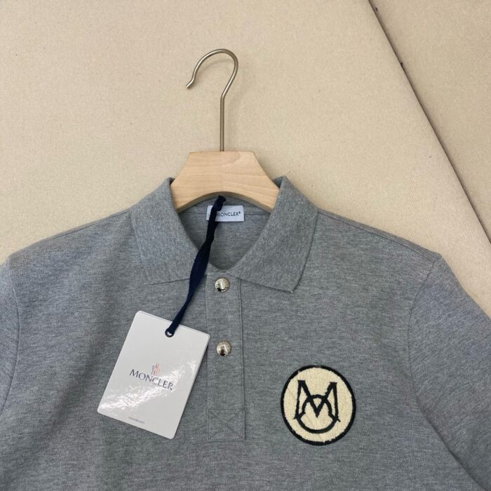 Maglietta polo grigia con logo ricamato, stile classico, cotone di alta qualità.