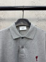 Maglietta polo grigia con cuore ricamato rosso, stile casual e dettagli di qualità.