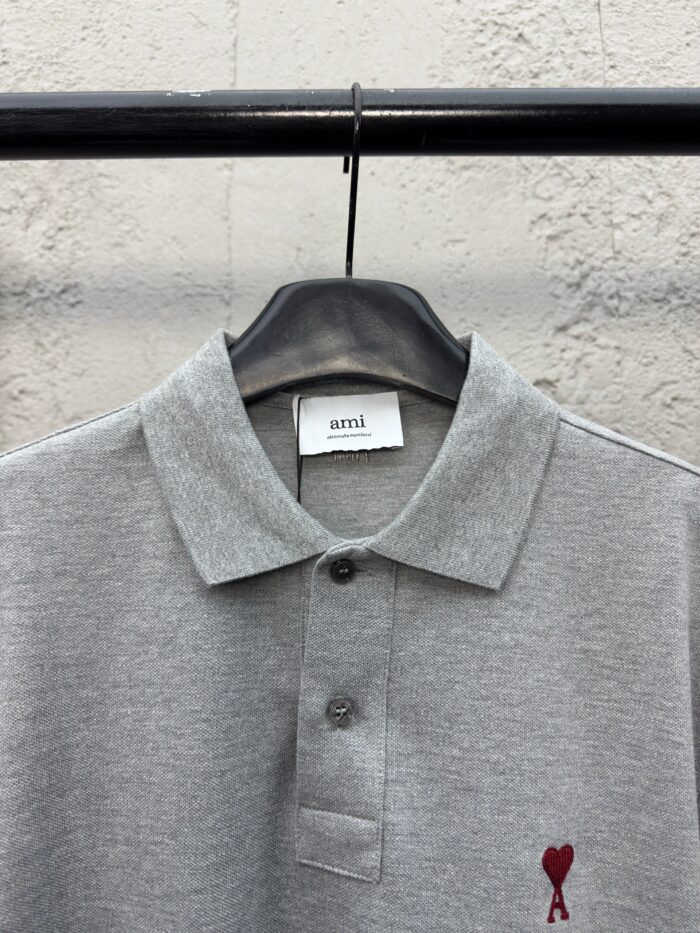 Maglietta polo grigia con cuore ricamato rosso, stile casual e dettagli di qualità.