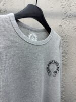 Maglietta grigia a collo rotondo con grafica decorativa nera, stile casual e versatile.