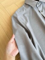 Camicia grigia elegante in cotone, manico che evidenzia qualità e dettagli sartoriali.