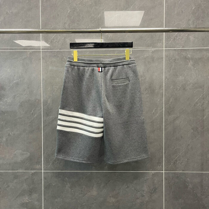 Pantaloncini sportivi grigi con strisce bianche, comfort e stile casuale.