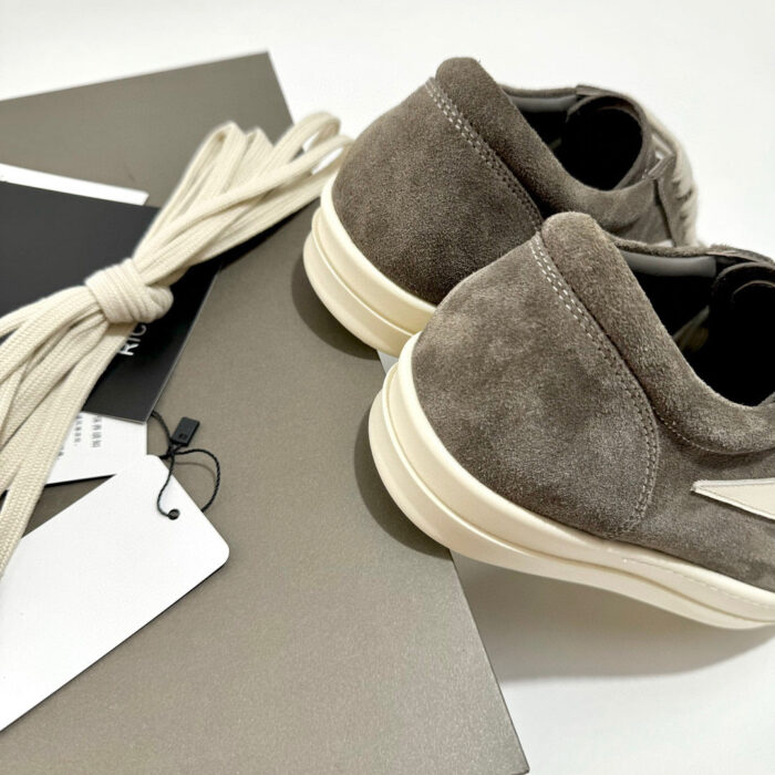Sneakers in suede grigio con suola bianca e lacci coordinati, stile casual ed elegante.
