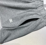 Pantaloncini sportivi grigi casual con elastico, tasche e logo bianco, comodi e versatili.