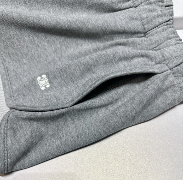 Pantaloncini sportivi grigi casual con elastico, tasche e logo bianco, comodi e versatili.