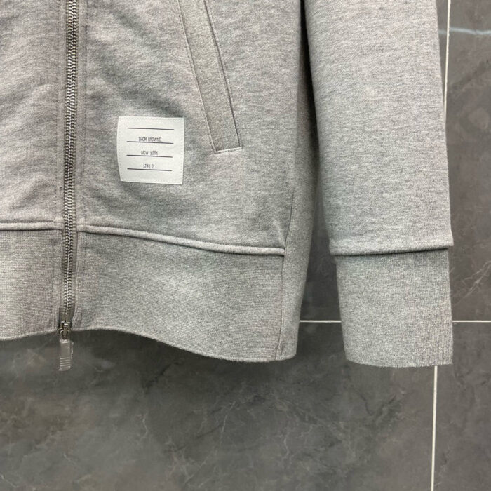 Felpa grigia con tasca e polsini a costine, adatta a look casual e athleisure.