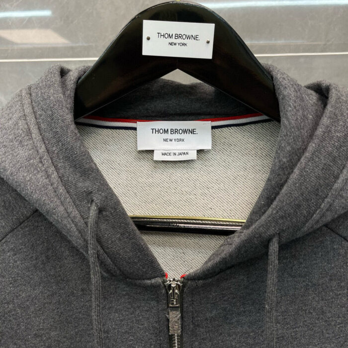 Felpa Thom Browne grigia in Giappone, dettagli iconici e materiali di alta qualità.