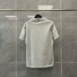 T-shirt grigia da dietro con dettaglio a righe, stile casual e moderno.
