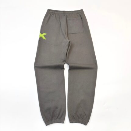 Pantaloni jogger grigi con logo neon giallo, vita ed elastici alle caviglie, stile sportivo.