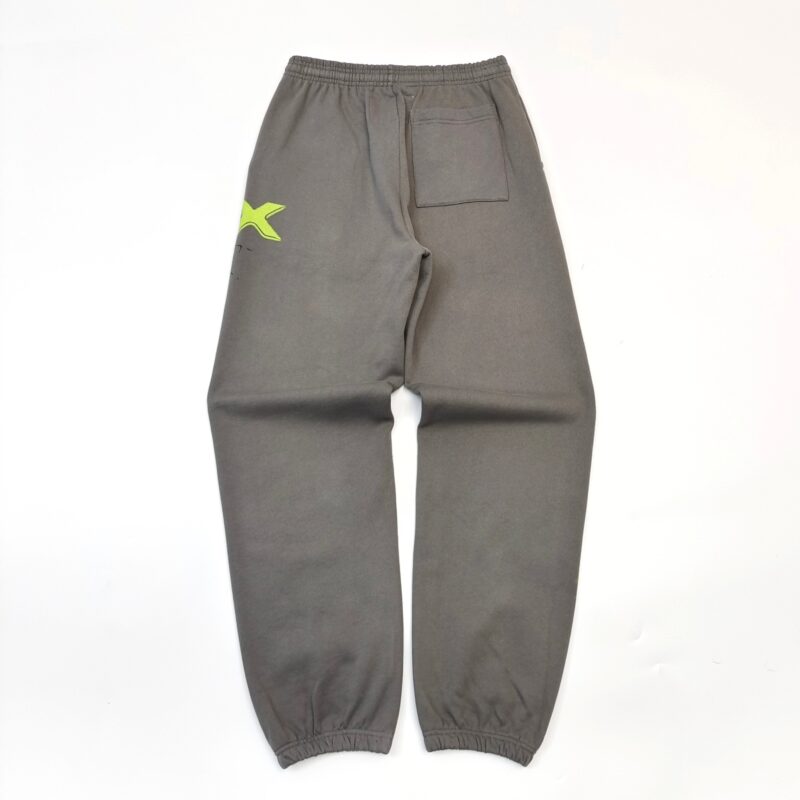 Pantaloni jogger grigi con logo neon giallo, vita ed elastici alle caviglie, stile sportivo.