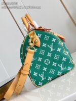 Borsa verde con logo monogramma, manici in pelle tan e tracolla regolabile elegante.