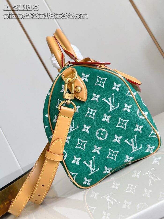 Borsa verde con logo monogramma, manici in pelle tan e tracolla regolabile elegante.