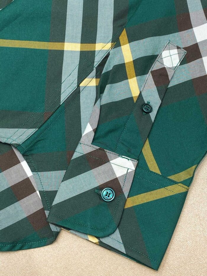 Camicia a quadri verde con polsino e bottone turchese, stile casual e dettagli curati.