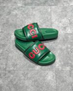 Sandali Gucci verdi con logo rosso, stile casual chic, comfort e lusso estivo.