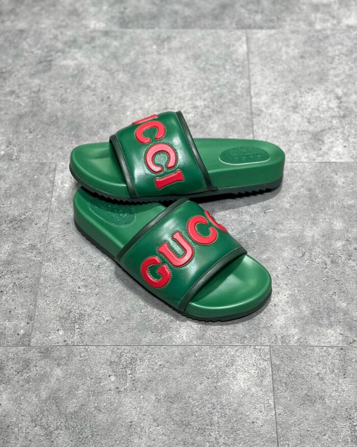 Sandali Gucci verdi con logo rosso, stile casual chic, comfort e lusso estivo.