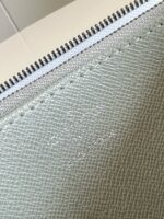 Portafoglio verde in pelle con zip elegante e dettagli di alta qualità.