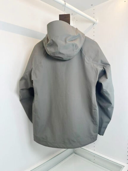 Giacchetto grigio leggero con cappuccio, stile minimalista e pratico da esterno.
