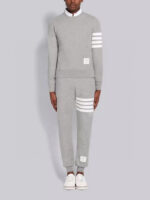Completo sportivo grigio con strisce bianche, felpa a collo alto e jogger aderenti.