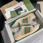Scarpe Gucci beige con strisce verdi e arancio in confezione di lusso originale.
