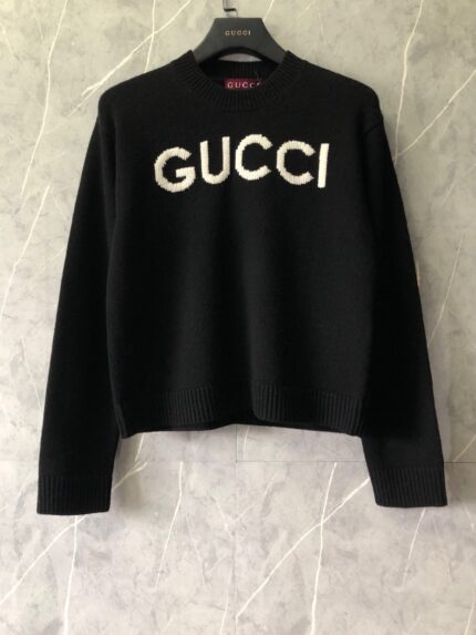Maglione cropped nero Gucci con logo bianco, design moderno, elegante e di tendenza.