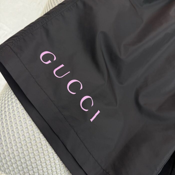 Logo Gucci rosa su abbigliamento nero moderno e elegante, dettaglio chic e di lusso.