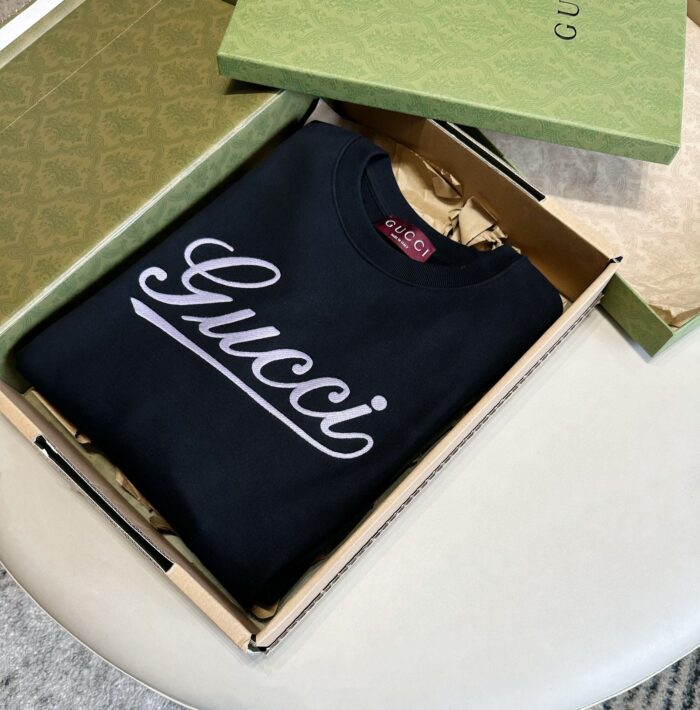 Maglione Gucci di lusso in confezione elegante su superficie raffinata.