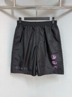 Pantaloncini Gucci neri con logo, dettagli viola e stile luxury casual per ogni occasione.