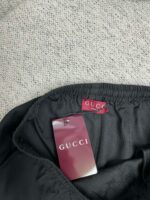 Dettaglio di un capo Gucci con etichette eleganti e tessuto di alta qualità.