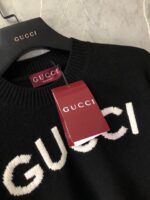 Maglione Gucci nero con logo bianco, tag rosso autentico, eleganza e lusso italiano.