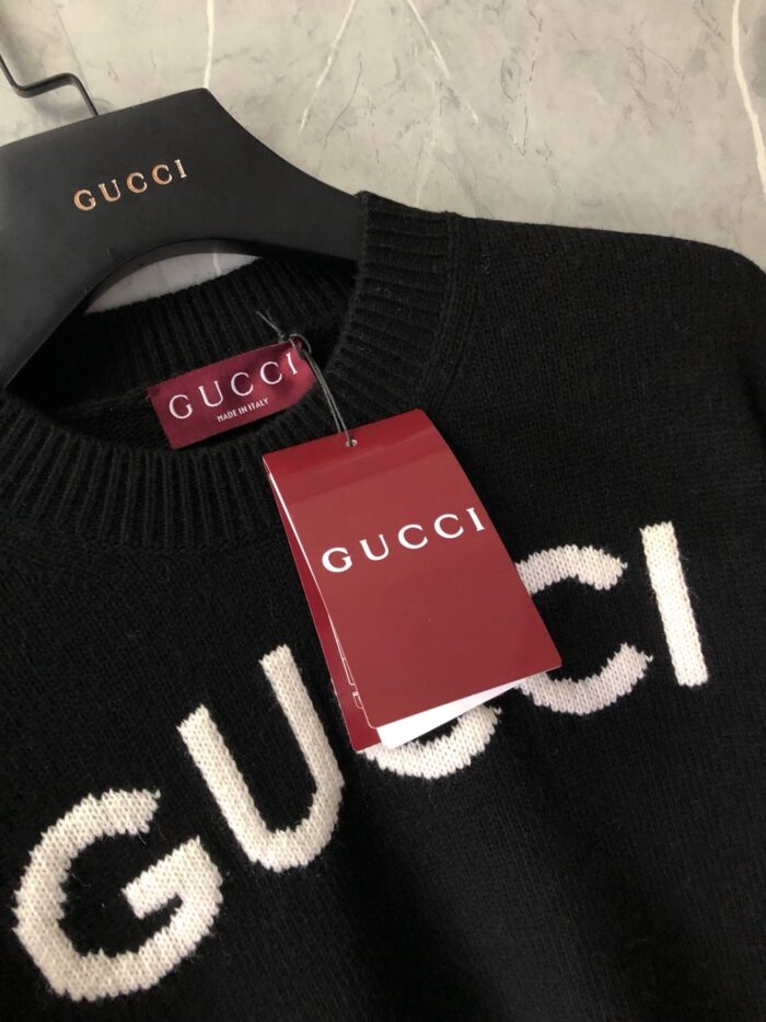 Maglione Gucci nero con logo bianco, tag rosso autentico, eleganza e lusso italiano.