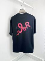 Maglietta nera Gucci con serpente rosa e logo elegante, stile streetwear e moda di lusso.