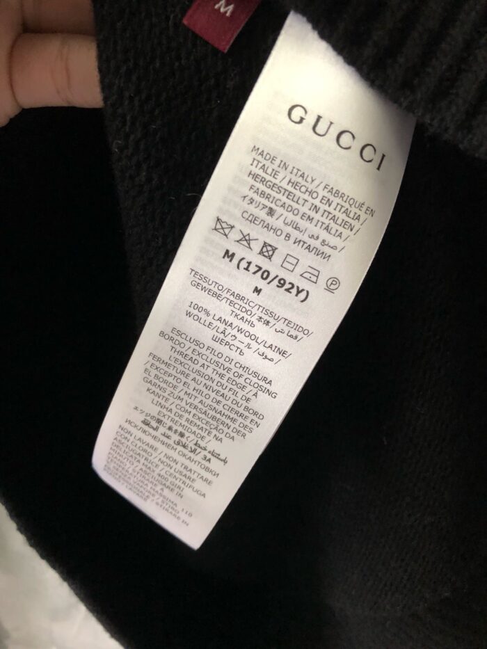 Etichetta Gucci su maglione di lusso con istruzioni e tag taglia M.