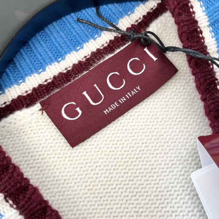 Etichetta Gucci su giacca a quadri in tessuto trame knit, Made in Italy, stile elegante.