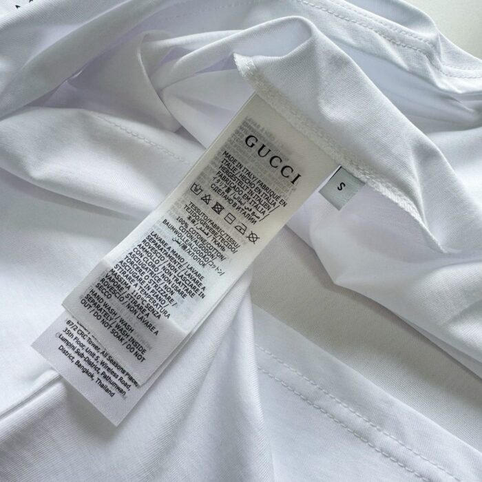Etichetta Gucci T-shirt bianca in cotone di alta qualità, con istruzioni cura e taglia S