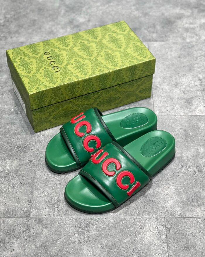 Sandali Gucci verdi con logo rosso e packaging elegante, stile moderno e lusso sofisticato.
