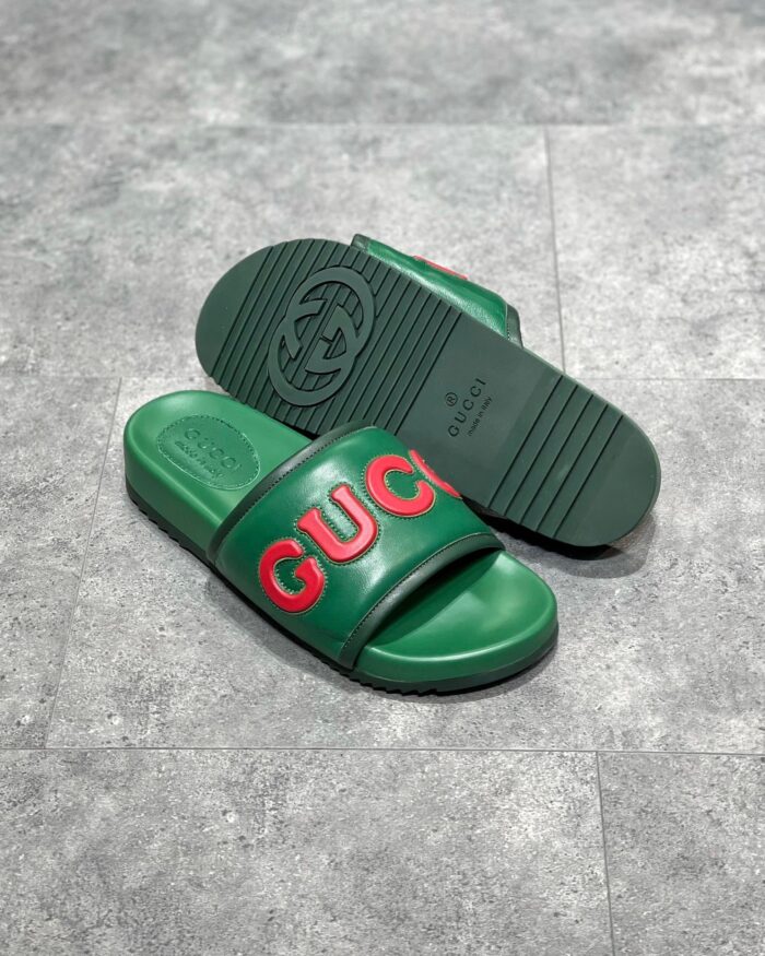 Sandali Gucci verde con logo rosso, stile elegante, comfort e design di lusso femminile.